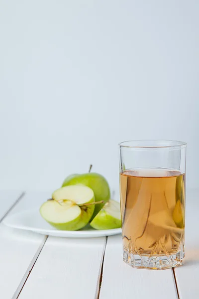 Suco de maçã com maçãs em uma mesa de madeira — Fotografia de Stock