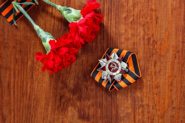 Sipariş St ve iki kırmızı çiçek ve George şerit üzerinde ahşap Vatanseverlik Savaşı