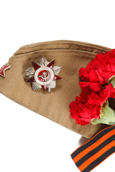 Vojenská čepice s červenými květy, Saint George stuhy a objednávky Velké vlastenecké války na bílém pozadí. ilustrativní úvodník. — Stock fotografie