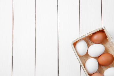 Yumurta beyaz arka plan üzerinde ahşap kutusunda