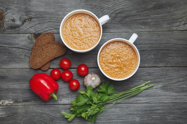 Sopa de gazpacho e ingredientes sobre fondo de madera oscura. Español —  Fotos de Stock