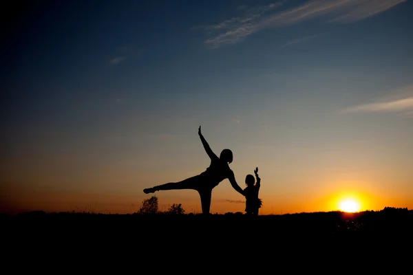 Silhouette, happy daugther with mother at sunset, summertime — Stock Photo, Image