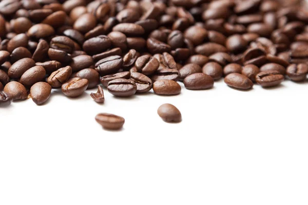 Geröstete Kaffeebohnen stapeln sich von oben auf weißem Hintergrund — Stockfoto