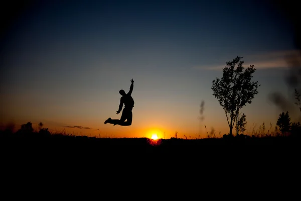 Silhouette of jumping man and beautiful sunset sky. Element of design. Business concept — Stock Photo, Image