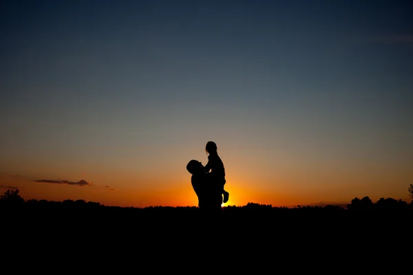 Silhouette of father and child on the outdoor on beautiful summer sunset - family — Stock Photo, Image