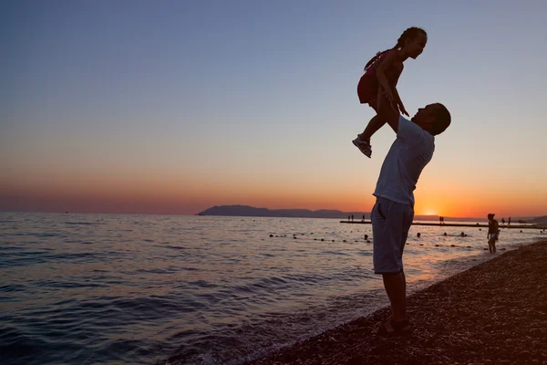 Bir baba kızını kadar günbatımında kaldırma silüeti