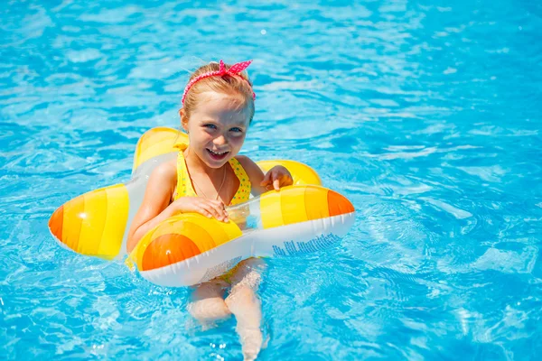 Portret van schattig gelukkig klein meisje plezier in zwembad, drijvend in blauw verfrissend water met grote rubberring, actieve zomervakantie op het strand — Stockfoto
