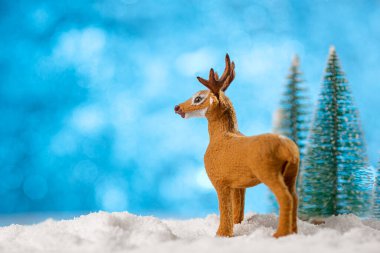 Noel kartı gebeliği. Noel oyuncağı geyik süslemesi Noel ağaçları ve karla.