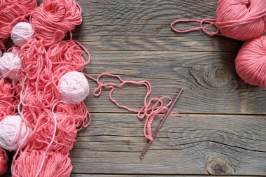 Çeşitli boyutlarda ve renkte yün yumakları, ahşap arka plan. El yapımı örgü konsepti. Üst görünüm, alanı kopyala