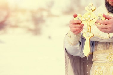Ortodoks altını nehre daldıran bir rahibin elleri. Rusya 'nın Epifanisi bayramı. Tonu ayarlanmış resim