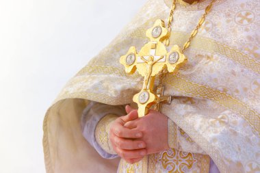 Altın haç bir rahibin ellerinde. Suyu kutsama zamanı.