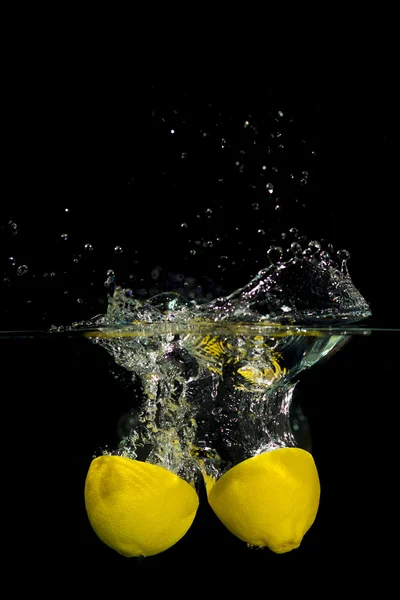 Lemon in water on black background — Stock Photo, Image