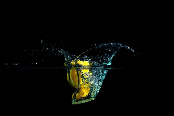 Citron dans l'eau sur fond noir — Photo