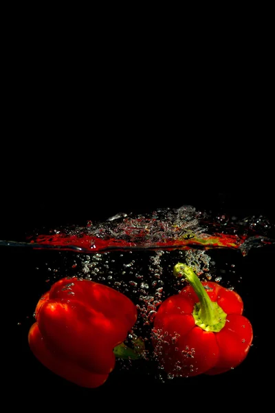 Peppar i vatten på en svart bakgrund — Stockfoto