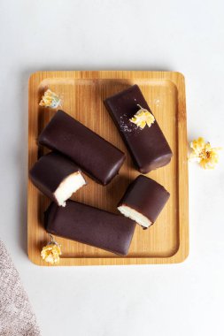 Tahta bir tahtanın üzerinde çikolataya bulanmış kaymak. Peynirli tatlı..