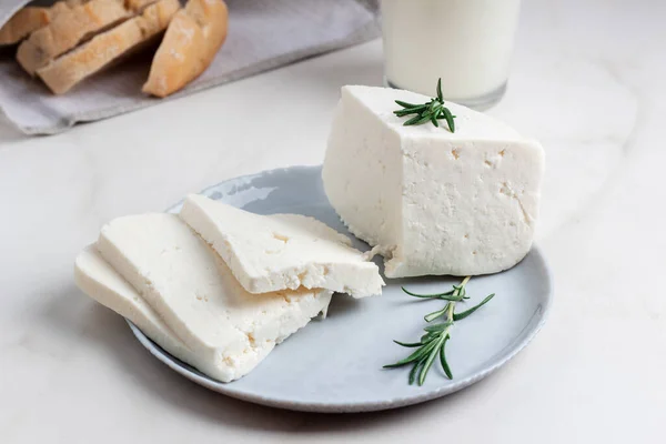 Le fromage Adyghe est coupé en morceaux sur une assiette grise. Fromage de chèvre tendre — Photo