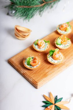 Krem peynirli tart ve ahşap bir masada kırmızı tuzlu somon. Parti için lezzetli bir porsiyon hafif atıştırmalık..