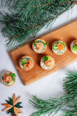 Krem peynirli tart ve ahşap bir masada kırmızı tuzlu somon. Parti için lezzetli bir porsiyon hafif atıştırmalık..