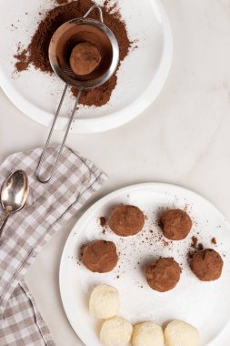 Ev yapımı Hint usulü vejetaryen tatlıları. Hindistan cevizi ve kakao topları kakaolu beyaz bir kasede..