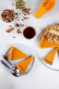 Mermer zemin üzerinde cam bir tabakta balkabağı turtası.