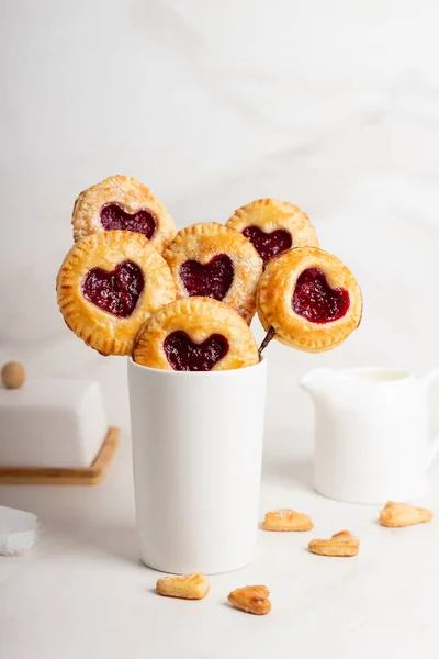 Маленькие вишневые пирожки макают на палочках в День Святого Валентина. Место для смс. Открытка — стоковое фото