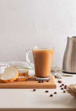 Tahtada süt ve dilimlenmiş somun ile taze demlenmiş kahve.