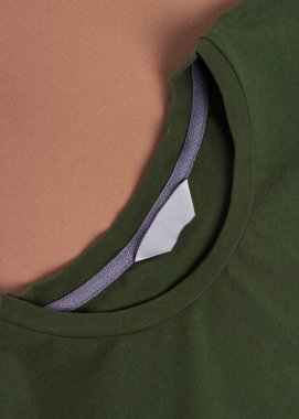 Boş etiketli koyu boş tişört, kahverengi arkaplanda boş model şablonu etiketi