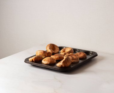 Pişirme kabında Yorkshire Pudingleri. Ev yapımı geleneksel tüylü altın Yorkshire Pudingleri.