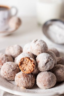 Ev yapımı süzme peynirli çörek topları ve hafif arka planda bir kasede pudra şekeri. Güzel kahvaltı.. 