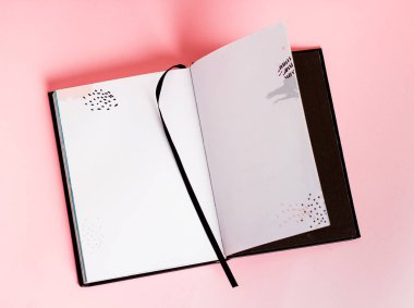 Pembe arka planda açık siyah defter olan işyeri. 