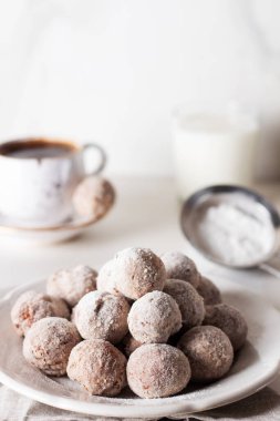 Ev yapımı süzme peynirli çörek topları ve hafif arka planda bir kasede pudra şekeri. Güzel kahvaltı.. 