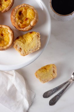 Pastel de Nata - beyaz mermer arka planda Portekiz yumurtalı muhallebi.