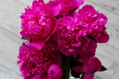 Ahşap zemindeki cam vazoda pembe şakayıklar.. 