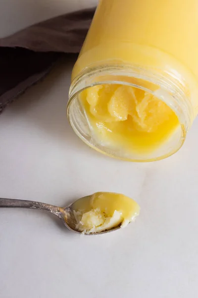 Indische Ghee geklärt Butter desi im Glas mit einem Löffel auf neutralem grauen Hintergrund mit Kopierraum — Stockfoto