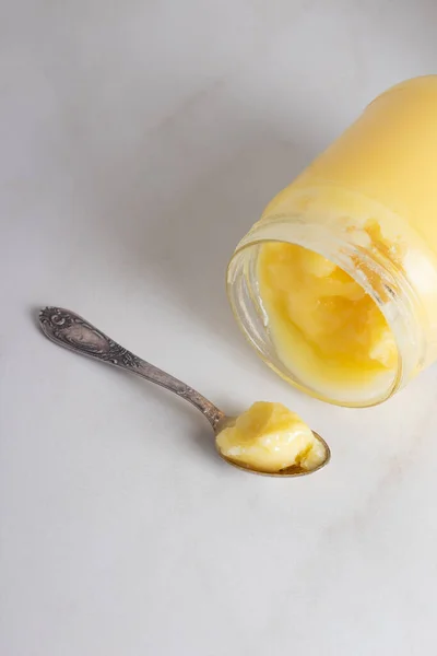 Indische Ghee geklärt Butter desi im Glas mit einem Löffel auf neutralem grauen Hintergrund mit Kopierraum — Stockfoto