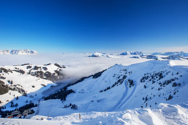 被雾和滑雪场包围的群山 — 图库照片