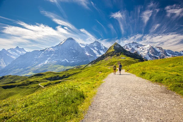 Young couple hiking to Kleine Scheideg — Stock Photo, Image