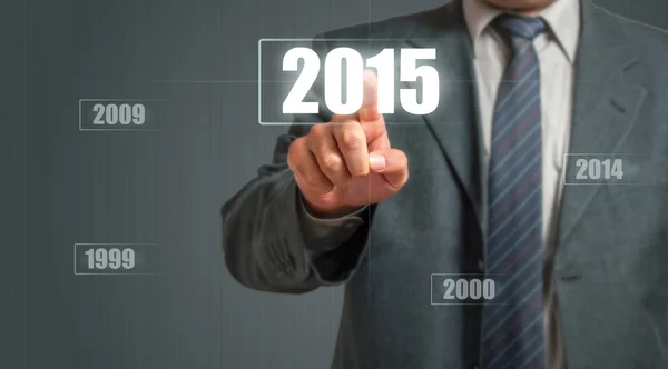 Uomo d'affari che tocca uno schermo immaginario e sceglie l'anno 2015 — Foto Stock