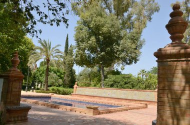 Tuğla ve kiremit kaplı mavi gölet Sevilla, Endülüs, İspanya parkında bahçe çardağı.