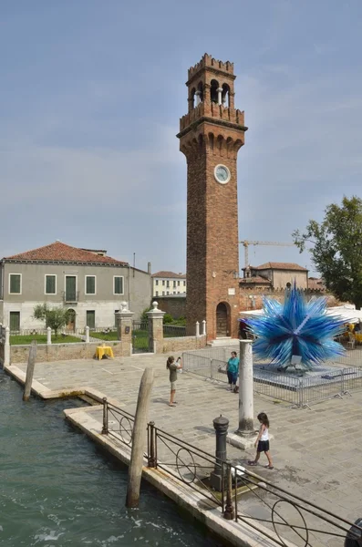 Tour de l'horloge et une sculpture en verre bleu murano — Photo