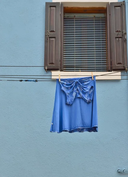 Blaues Kleid auf blauem Haus — Stockfoto