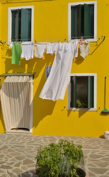 Wäsche waschen hängt an gelber Fassade — Stockfoto