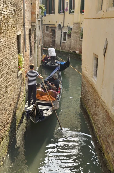 Venice, Italy - August 11, 2014: Gondolas passing by a narrow canal — Stock Photo, Image