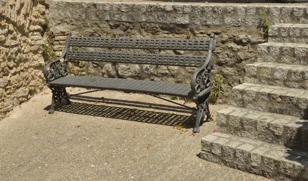 Eisenbank auf Steinmauer — Stockfoto