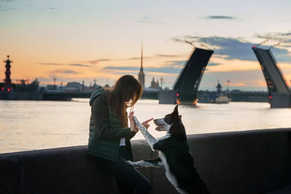 Девочка и собака на фоне разводных мостов в Санкт-Петербурге — стоковое фото