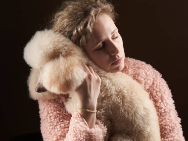 Kıvırcık kız ve kaniş. Sahibine benzeyen bir köpek. Stüdyoda portre