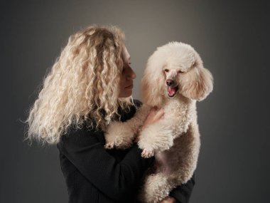 Kıvırcık kız ve kaniş. Sahibine benzeyen bir köpek. Stüdyoda portre