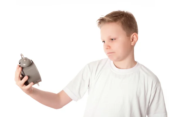 Jonge jongen kijkt de alarmklok over de witte — Stockfoto