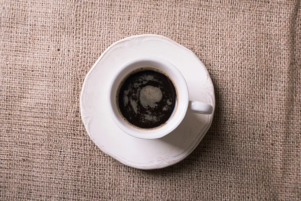 Tasse Kaffee auf Sacktuch Hintergrund — Stockfoto