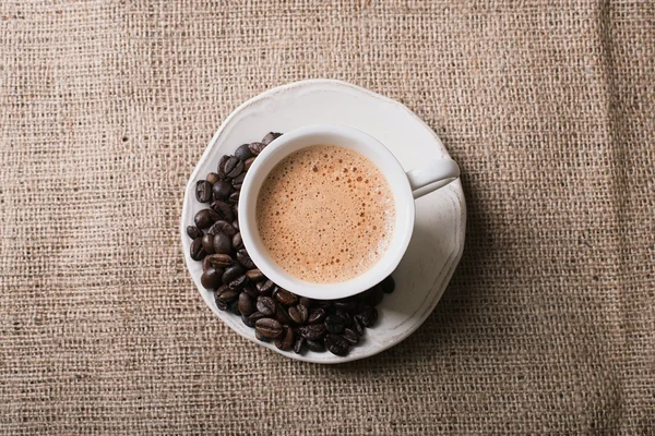 Café fresco y granos de café sobre tela de saco —  Fotos de Stock